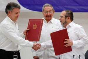 O presidente Santos cumprimenta o guerrilheiro Timochenko sob o olhar satisfeito de Raul Castro, no fim das conversações em Havana