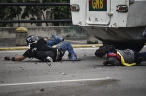 Carros de combate da Guarda Nacional Bolivariana passa por cima de manifestantes na  capital venezuelana