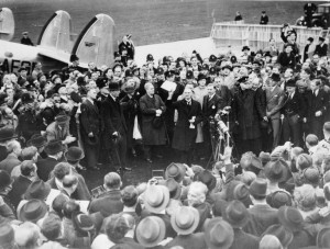 Neville Chamberlain, em sua chegada ao aeroporto de Heston (Londres), em 30 de Setembro de 1938, após seu encontro com Hitler em Munique. Em sua mão ele tem o acordo de paz feito entre Reino Unido e Alemanha.