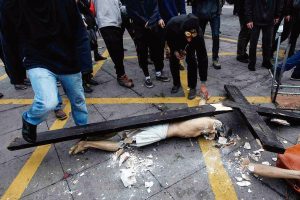 Violenta manifestação esquerdista profana igreja no centro de Santiago do Chile e retira de seu interior, sem nenhuma reação dos presentes, um antigo Crucifixo, que é brutal e sacrilegamente golpeado, atirado ao chão e quebrado.