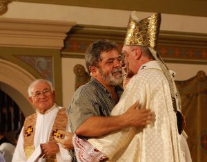 Lula sendo abraÃ§ado pelo Cardeal Dom ClÃ¡udio Hummes, observado pelo Bispo Dom Sandalo Bernardino